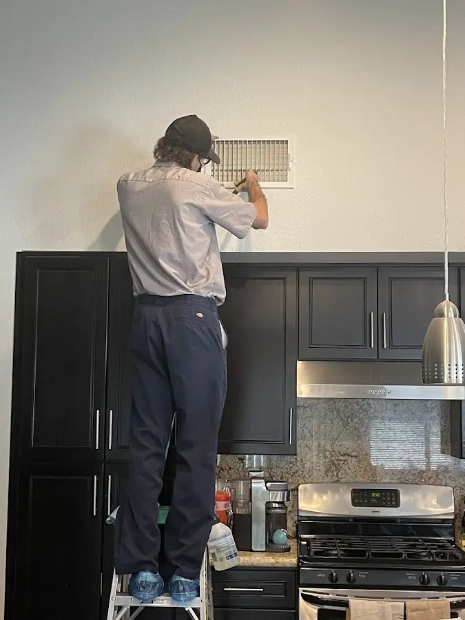 Technician inspecting an air vent during HVAC service in Red Wing